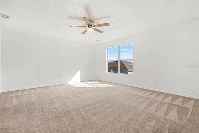 carpeted empty room with a textured ceiling and ceiling fan