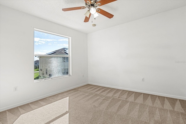 carpeted empty room featuring ceiling fan and a textured ceiling