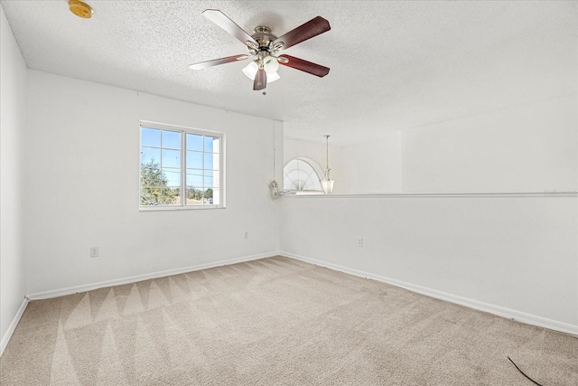 carpeted spare room with ceiling fan and a textured ceiling