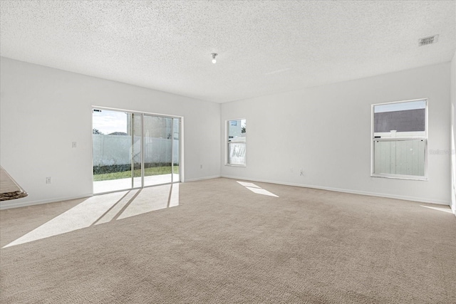 carpeted empty room featuring a textured ceiling