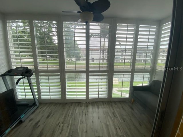 unfurnished sunroom featuring ceiling fan and plenty of natural light