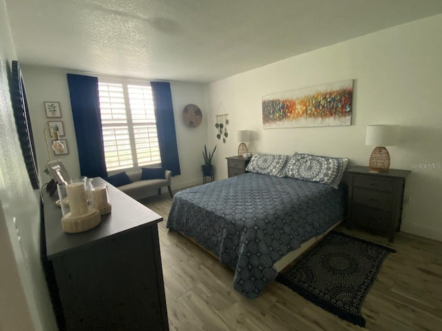 bedroom featuring light hardwood / wood-style flooring and a textured ceiling