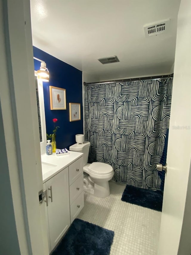 bathroom with tile patterned floors, toilet, vanity, and a shower with curtain