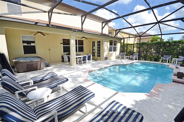 view of swimming pool featuring ceiling fan, a patio, a lanai, and a hot tub