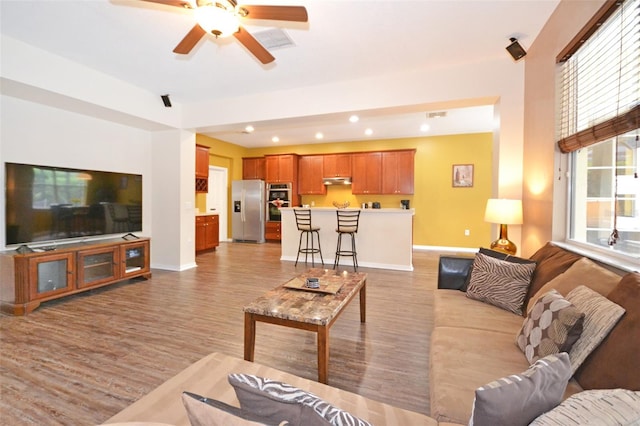 living room featuring light hardwood / wood-style floors and ceiling fan