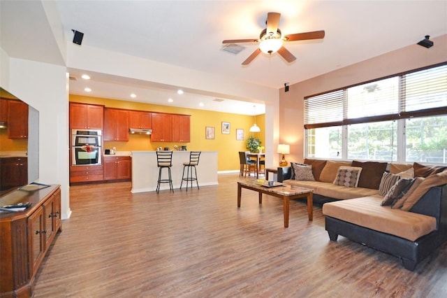 living room with ceiling fan and light hardwood / wood-style flooring