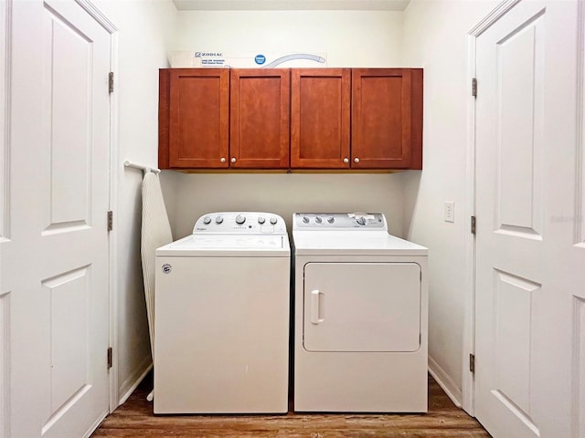 laundry room with washer and dryer, cabinets, and dark hardwood / wood-style flooring