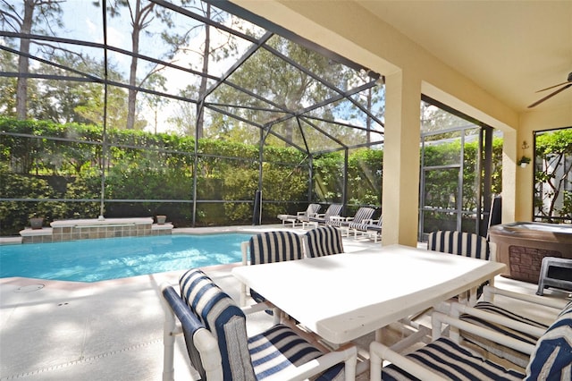 view of pool with ceiling fan, a jacuzzi, glass enclosure, and a patio