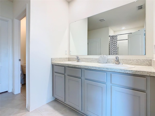 bathroom featuring toilet, curtained shower, vanity, and tile patterned floors