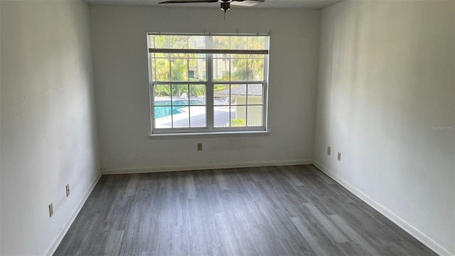 unfurnished room featuring ceiling fan and dark wood-type flooring