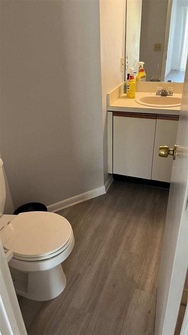 bathroom featuring vanity, hardwood / wood-style floors, and toilet