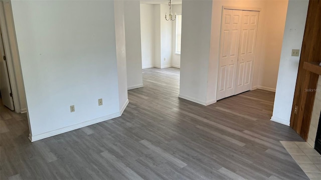 spare room with hardwood / wood-style floors and a notable chandelier