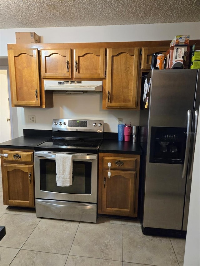 kitchen with under cabinet range hood, dark countertops, appliances with stainless steel finishes, and light tile patterned flooring