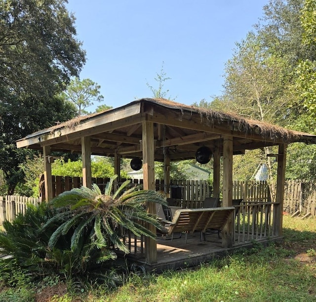 surrounding community with fence, a deck, and a gazebo