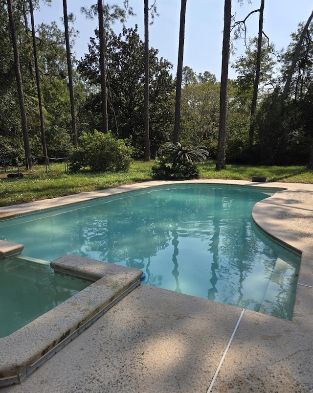 view of pool with a pool with connected hot tub