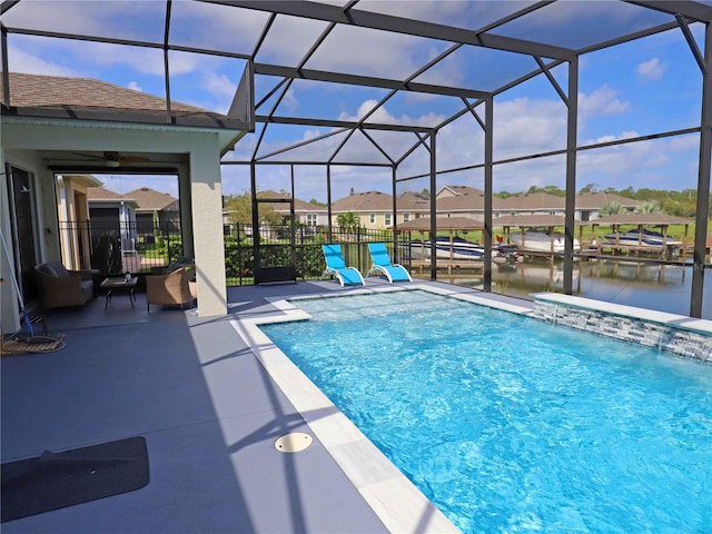 view of swimming pool with a water view, glass enclosure, a patio, and pool water feature