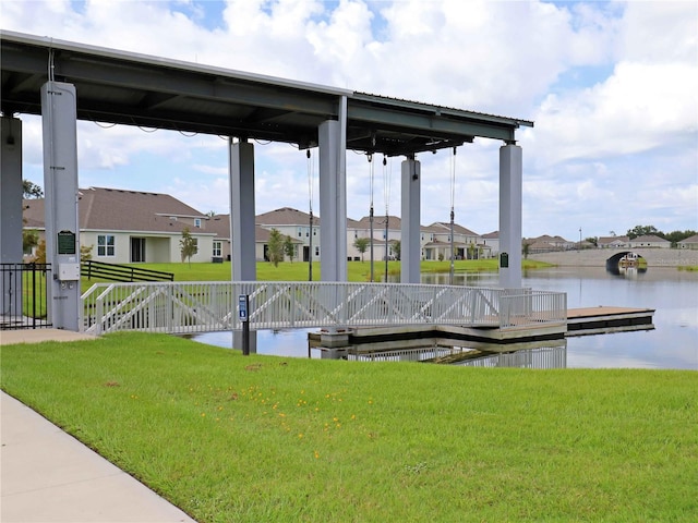 dock area featuring a lawn and a water view