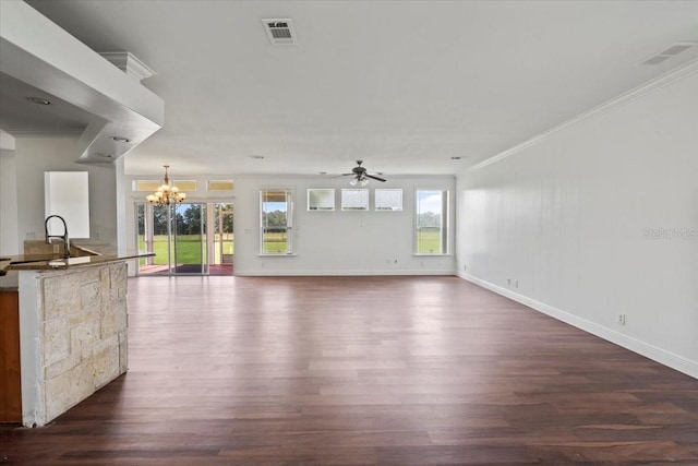 unfurnished living room with dark wood-type flooring, ceiling fan with notable chandelier, crown molding, and sink