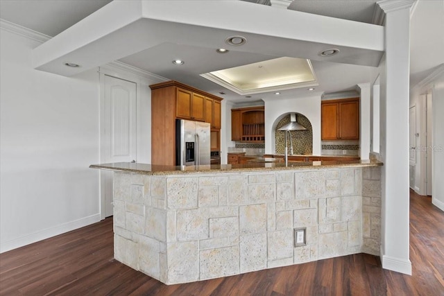 kitchen featuring stainless steel refrigerator with ice dispenser, crown molding, kitchen peninsula, and dark hardwood / wood-style flooring