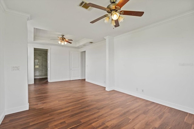 empty room featuring ceiling fan, a raised ceiling, dark hardwood / wood-style floors, and ornamental molding