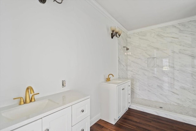 bathroom featuring wood-type flooring, a tile shower, ornamental molding, and vanity