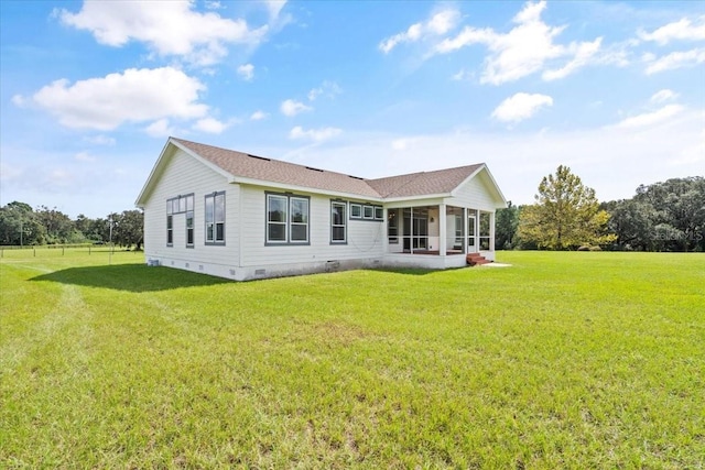 rear view of house with a sunroom and a yard