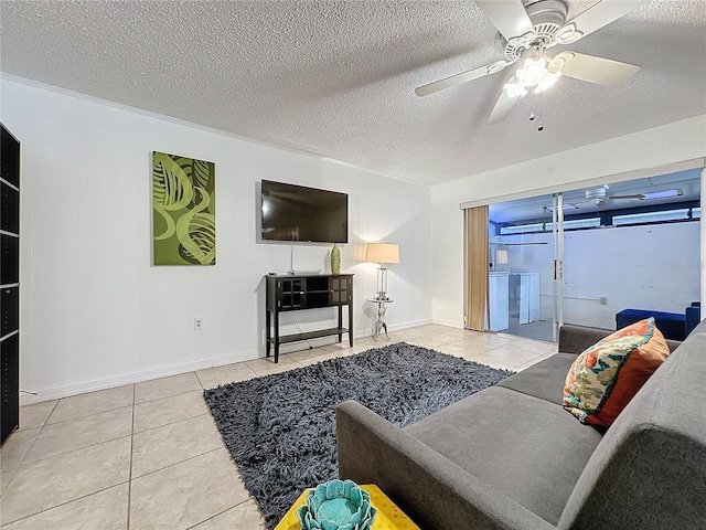 living room featuring light tile patterned flooring, ceiling fan, and a textured ceiling