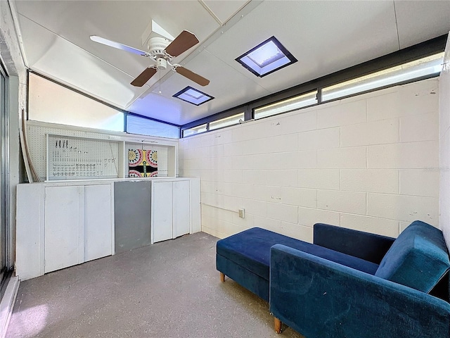 sitting room featuring ceiling fan and a skylight