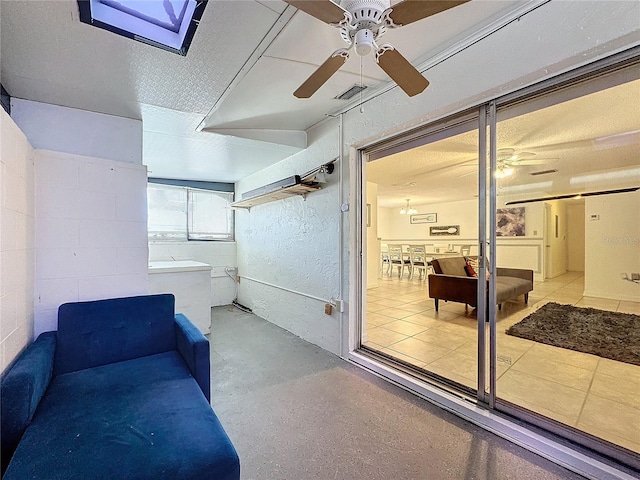 interior space with a skylight and ceiling fan