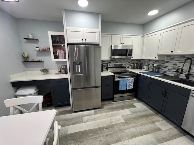 kitchen with white cabinets, stainless steel appliances, backsplash, and sink