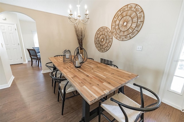 dining area with dark hardwood / wood-style floors and a chandelier