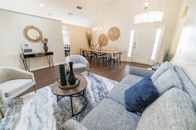 living room featuring high vaulted ceiling, an inviting chandelier, and dark hardwood / wood-style flooring