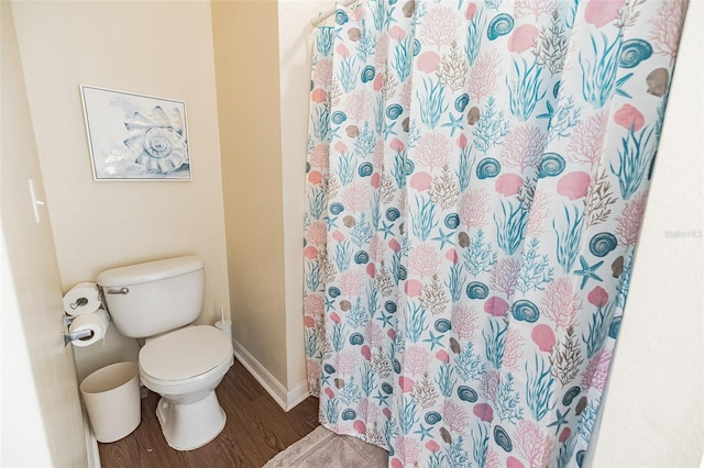 bathroom featuring hardwood / wood-style flooring, toilet, and curtained shower