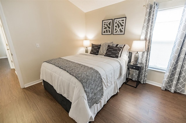 bedroom with dark hardwood / wood-style floors