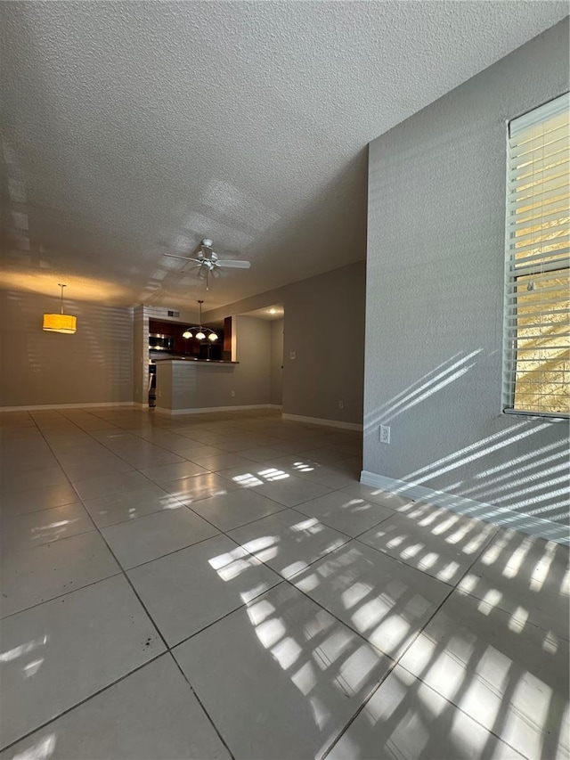 unfurnished living room with ceiling fan and a textured ceiling