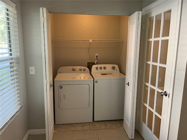 laundry room with light tile patterned flooring and washer and clothes dryer