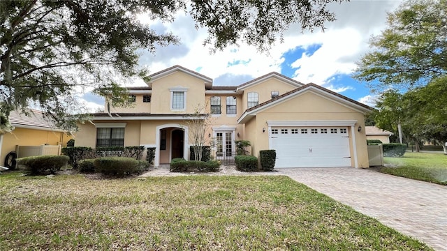 view of property with a garage and a front lawn