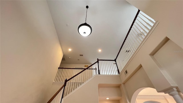 staircase with a high ceiling and decorative columns