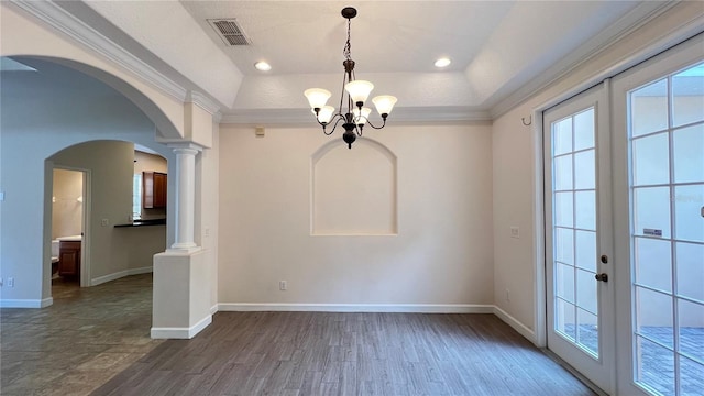 interior space with a tray ceiling, french doors, and ornamental molding