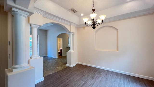 empty room with a textured ceiling, an inviting chandelier, dark hardwood / wood-style flooring, and ornamental molding