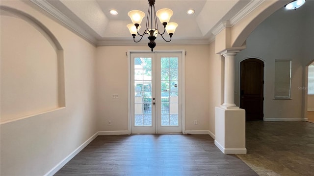 entryway featuring french doors, dark hardwood / wood-style flooring, a chandelier, decorative columns, and crown molding