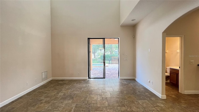 unfurnished room featuring a towering ceiling