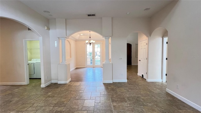 unfurnished room with french doors, separate washer and dryer, crown molding, and a notable chandelier