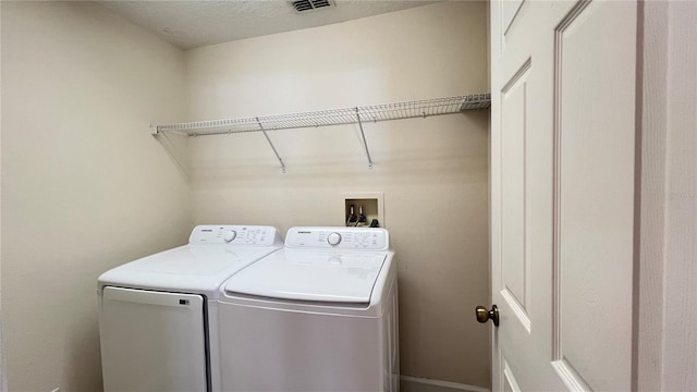 washroom featuring separate washer and dryer and a textured ceiling