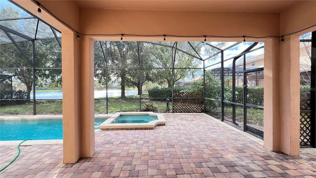 view of pool with a patio, a lanai, and an in ground hot tub