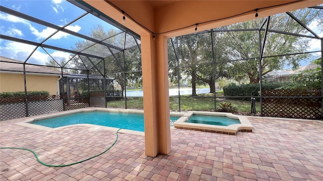 view of swimming pool with a water view, glass enclosure, an in ground hot tub, and a patio area