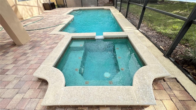 view of swimming pool with glass enclosure and a patio area