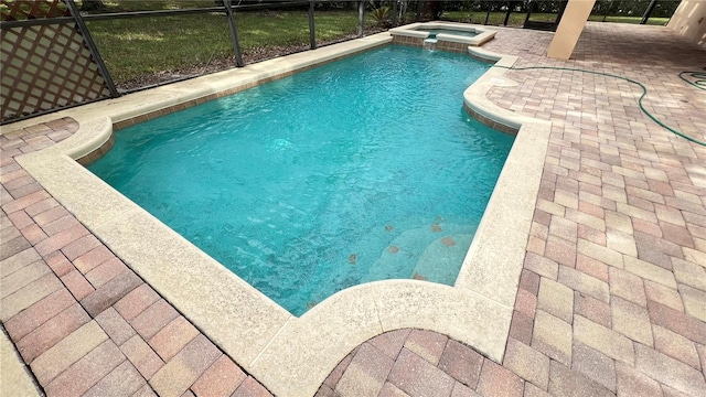 view of pool with a patio, a lanai, and an in ground hot tub