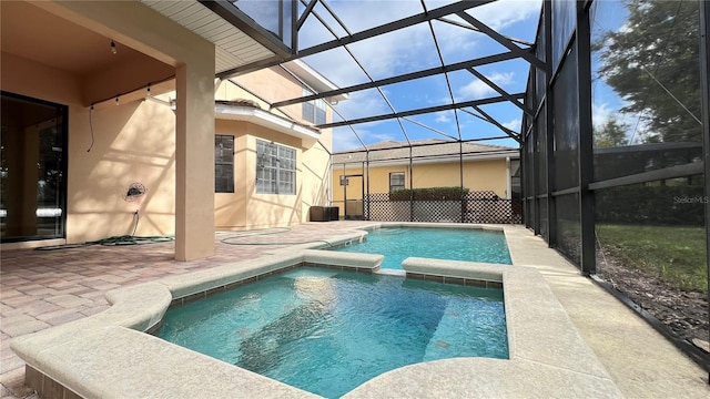 view of pool featuring glass enclosure, a patio, and an in ground hot tub