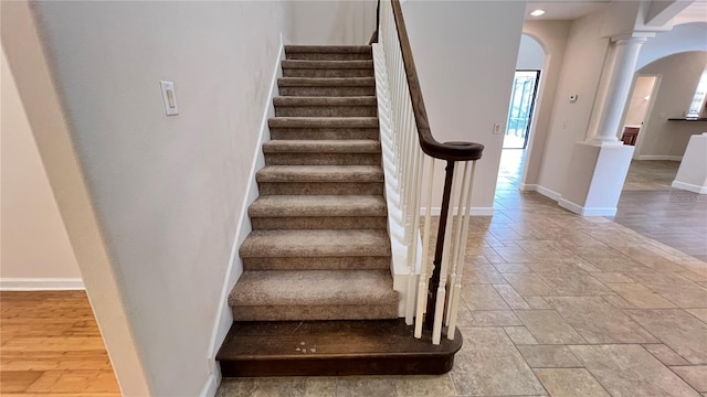 stairway featuring hardwood / wood-style floors and decorative columns